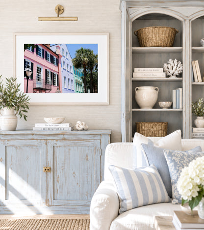 Color fine art photograph of Rainbow Row on East Bay Street in Charleston, South Carolina — pink, lavender, and mint green pastel facades with wrought iron balconies and palm trees against a blue sky
