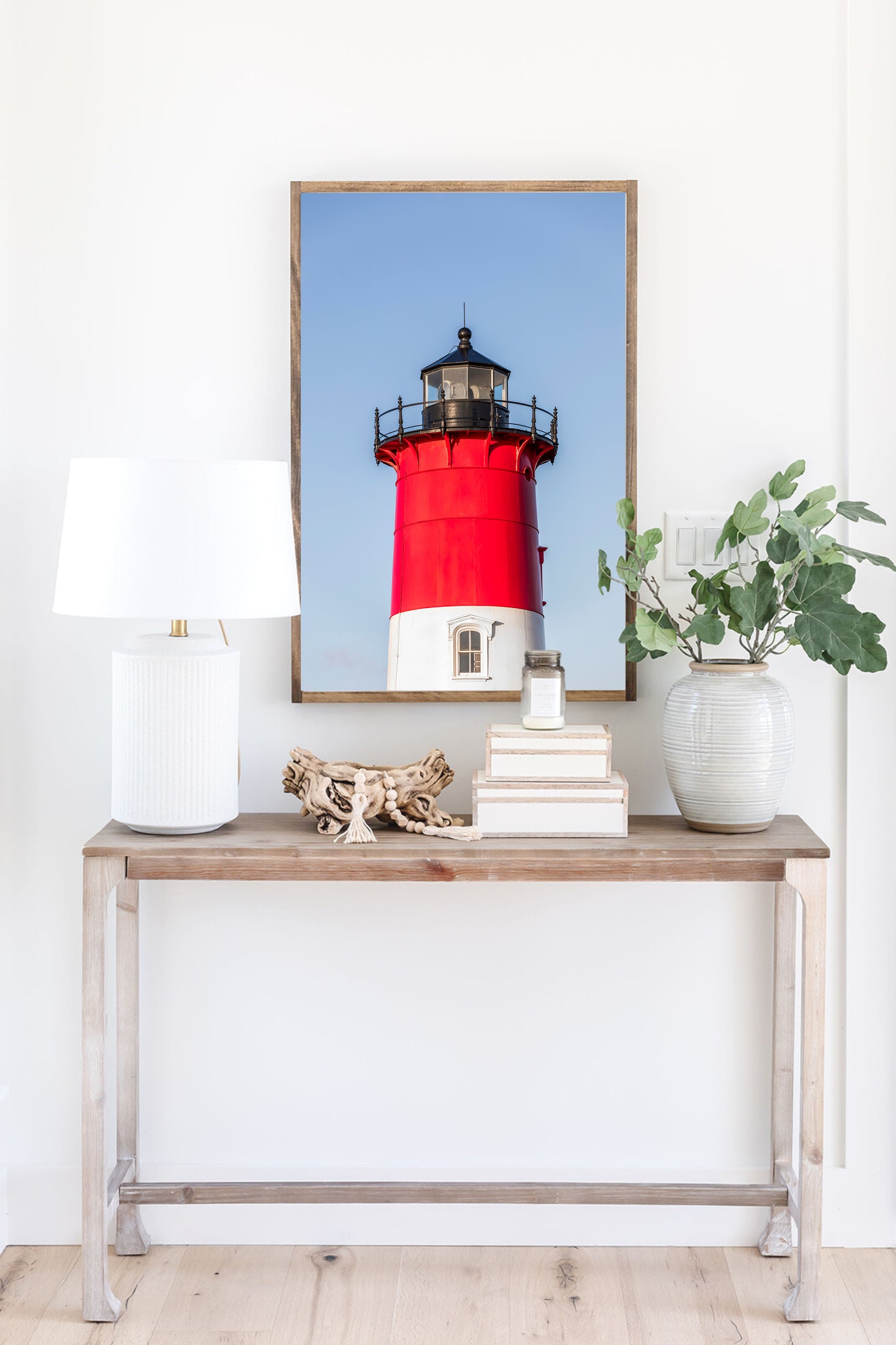 Vertical photograph of the red and white Nauset Lighthouse in Eastham, Massachusetts, set against a clear blue sky with no dunes or beach in view