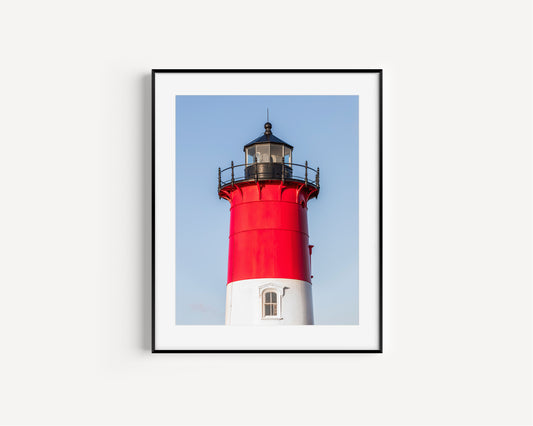 Vertical photograph of the red and white Nauset Lighthouse in Eastham, Massachusetts, set against a clear blue sky with no dunes or beach in view