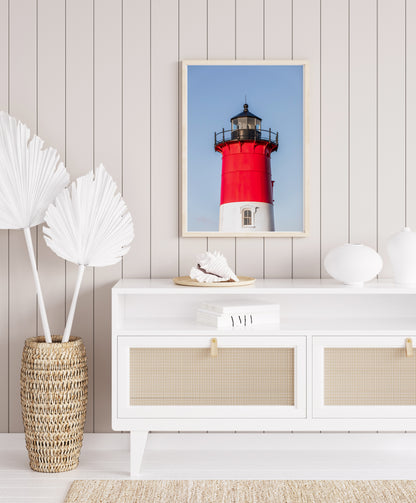 Vertical photograph of the red and white Nauset Lighthouse in Eastham, Massachusetts, set against a clear blue sky with no dunes or beach in view