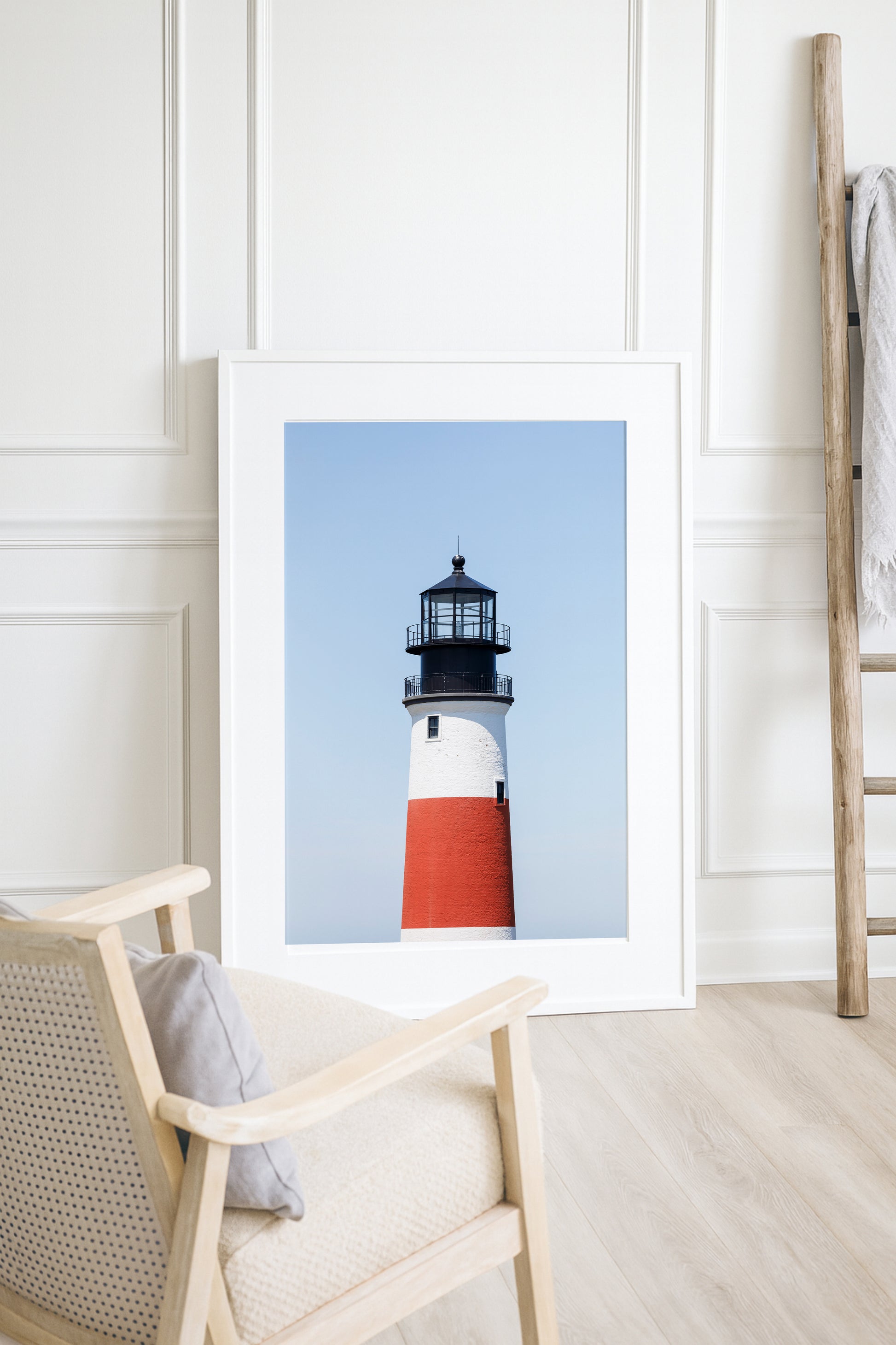 Color fine art photograph of Sankaty Head Lighthouse on Nantucket Island — red and white banded tower against a soft blue sky.