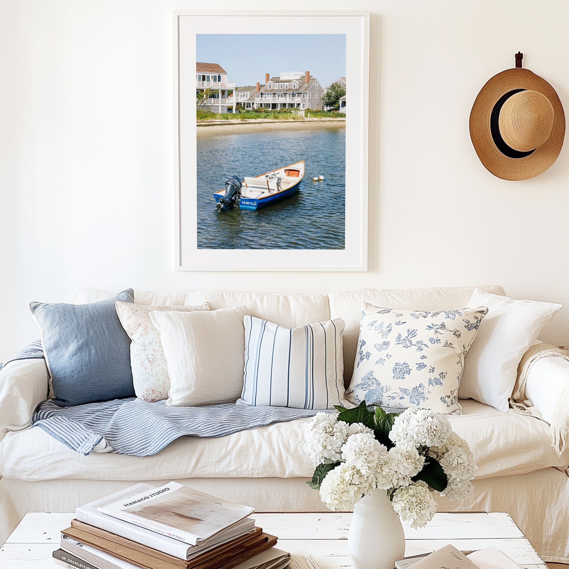 Vertical beach photography print of a small blue boat floating in Nantucket harbor, with Cape Cod-style houses and sandy shoreline in the background — perfect for nautical home decor and coastal wall art.